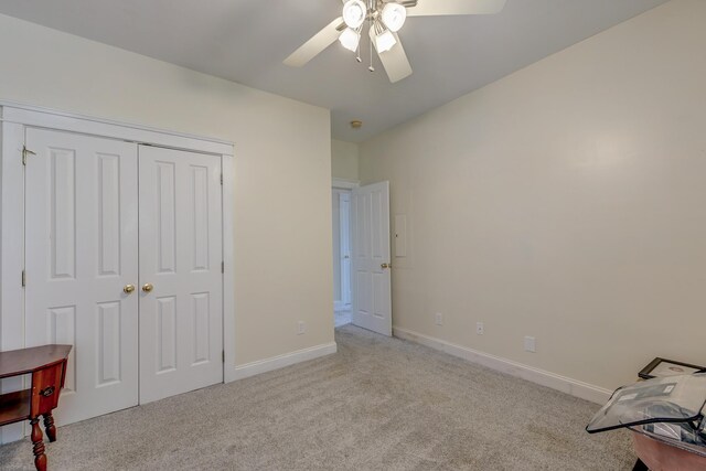 unfurnished bedroom featuring carpet flooring, baseboards, ceiling fan, and a closet