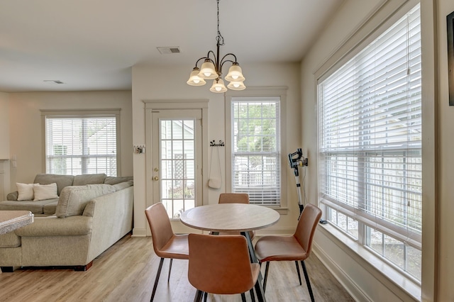 dining room featuring light wood-style flooring, a chandelier, and baseboards