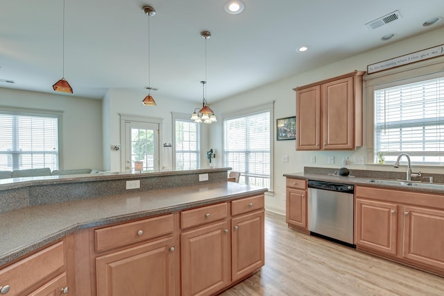 kitchen featuring stainless steel dishwasher, a sink, light wood finished floors, a chandelier, and pendant lighting
