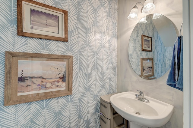 bathroom with wallpapered walls and a sink