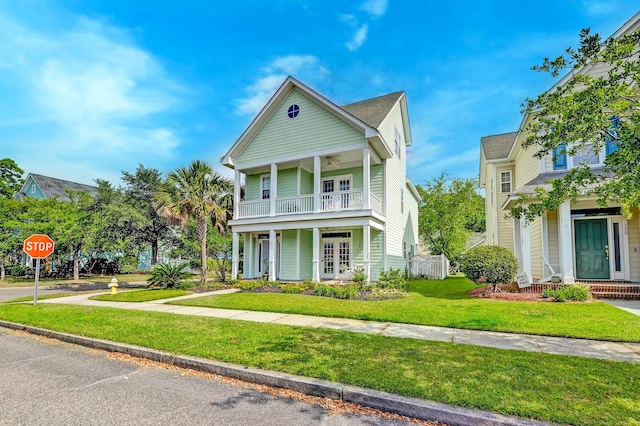 view of front of property with a balcony, french doors, a front yard, and covered porch