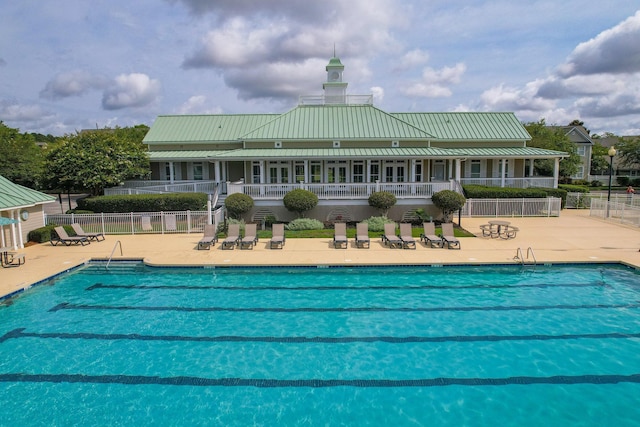 community pool featuring fence and a patio area
