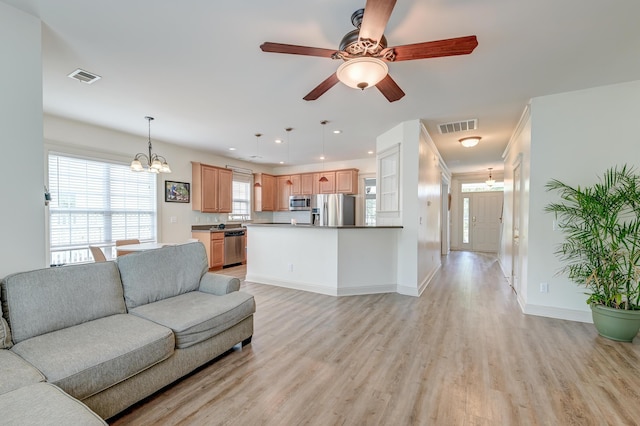 living room featuring a chandelier, light wood finished floors, baseboards, ceiling fan, and recessed lighting