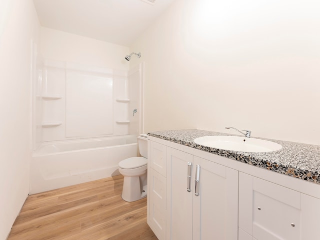 full bathroom featuring hardwood / wood-style floors, vanity, toilet, and bathing tub / shower combination