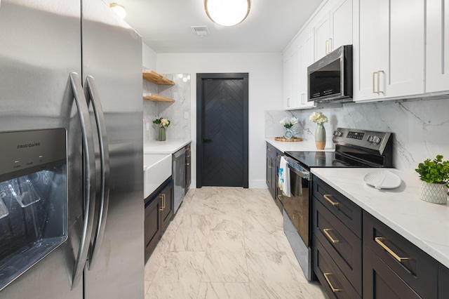 1129 Dickson Ave, Hanahan, SC 29410 - kitchen with appliances with stainless steel finishes, white cabinets, open shelves, decorative backsplash, and light marble finish flooring