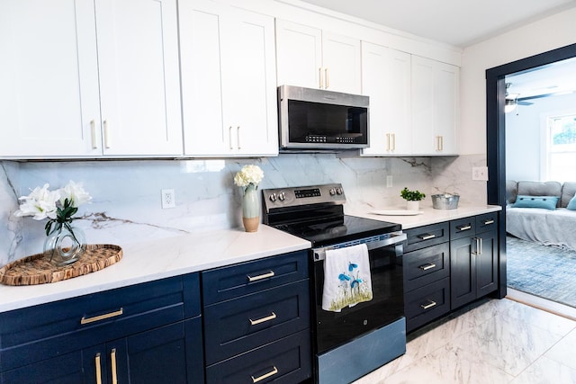 1129 Dickson Ave, Hanahan, SC 29410 - kitchen featuring appliances with stainless steel finishes, white cabinets, light marble finish flooring, backsplash, and blue cabinetry