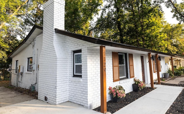 1129 Dickson Ave, Hanahan, SC 29410 - view of side of home with a chimney, brick siding, and covered porch