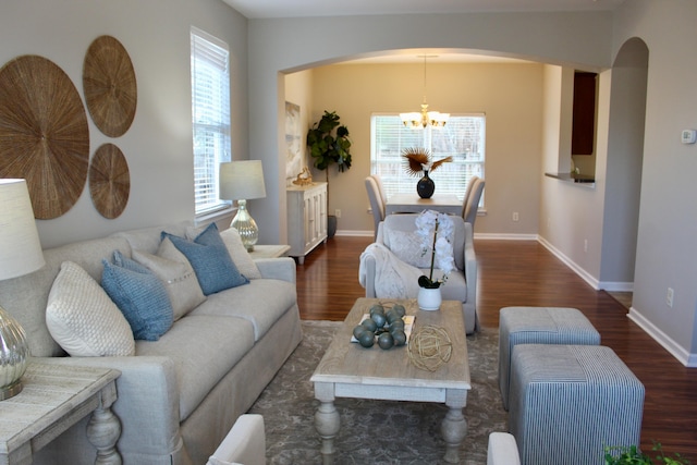 living room with a chandelier and dark wood-type flooring