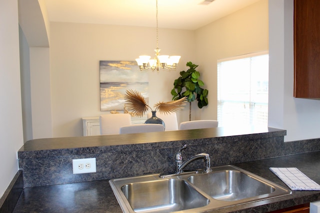 kitchen featuring sink, decorative light fixtures, and a notable chandelier