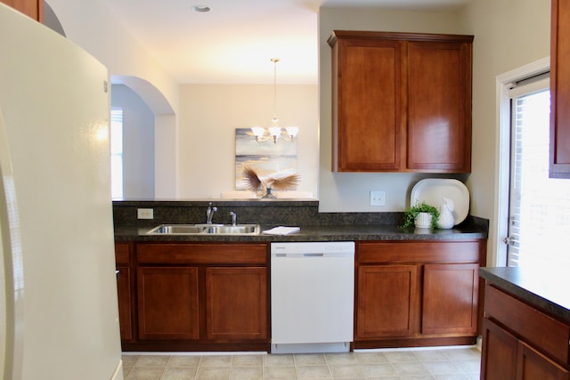 kitchen with white dishwasher, a notable chandelier, pendant lighting, and sink