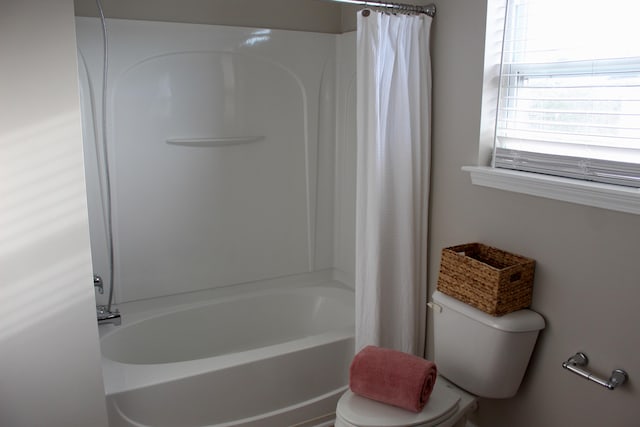 bathroom featuring toilet and shower / tub combo with curtain