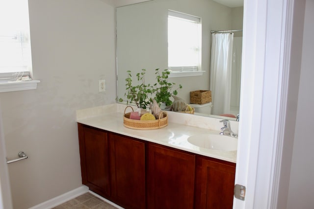 bathroom featuring tile patterned floors, walk in shower, vanity, and toilet