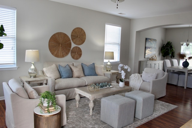 living room featuring dark wood-type flooring and an inviting chandelier