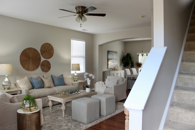 living room featuring wood-type flooring and ceiling fan with notable chandelier