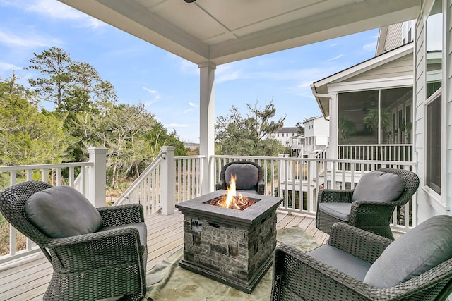 wooden terrace featuring a fire pit and a sunroom