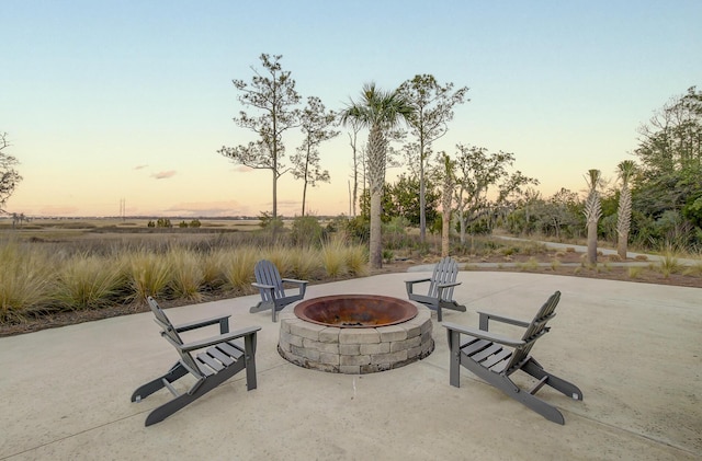 patio terrace at dusk featuring an outdoor fire pit