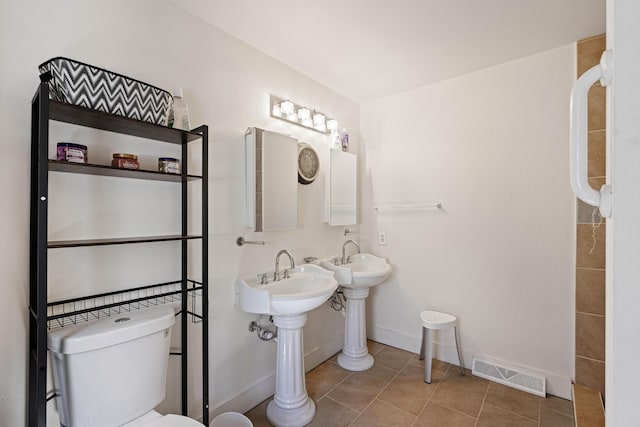 bathroom featuring visible vents, baseboards, toilet, and tile patterned flooring