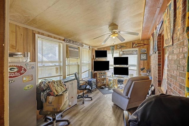 home office with wooden walls, a ceiling fan, brick wall, light wood-style floors, and a wall mounted air conditioner