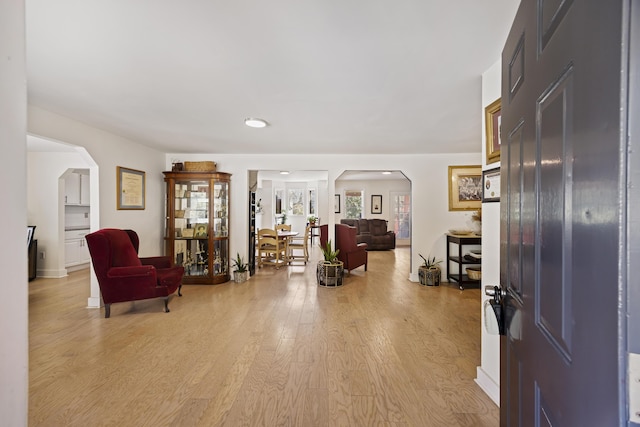 entryway featuring arched walkways and light wood-style floors