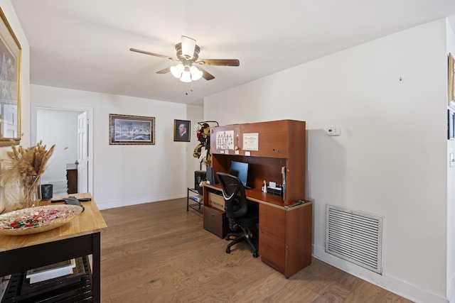 office area featuring ceiling fan, baseboards, visible vents, and light wood-type flooring