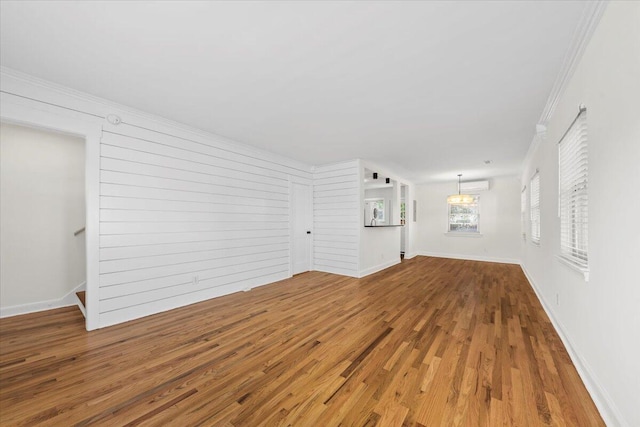 unfurnished living room with wood-type flooring and ornamental molding