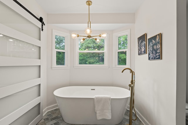 5950 Kelseys Mill Rd, Ravenel, SC 29470 - bathroom featuring a soaking tub, baseboards, stone finish flooring, and a notable chandelier