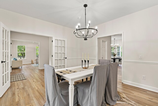 5950 Kelseys Mill Rd, Ravenel, SC 29470 - dining space with light wood-style flooring, french doors, a notable chandelier, and baseboards