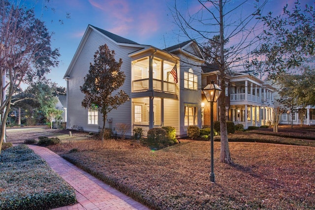 property exterior at dusk featuring a balcony