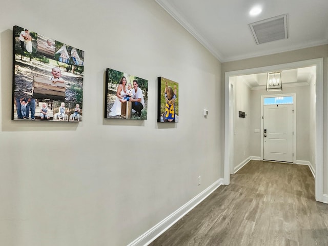 foyer entrance with ornamental molding and hardwood / wood-style flooring