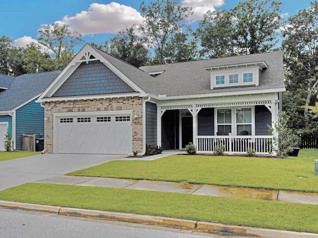 craftsman inspired home featuring a garage, a front lawn, and covered porch