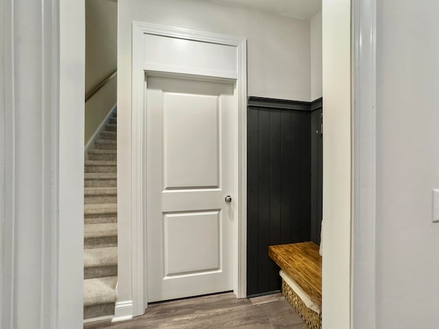 mudroom with wood walls and hardwood / wood-style floors