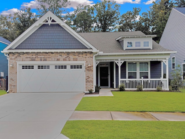 craftsman house featuring a porch, a garage, and a front yard