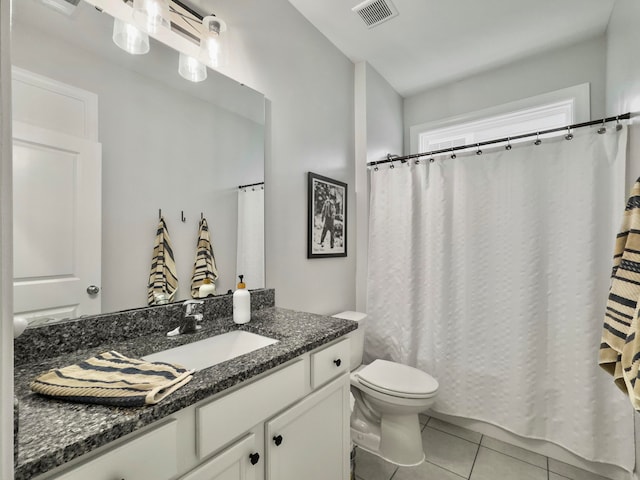 bathroom with a shower with curtain, vanity, toilet, and tile patterned floors