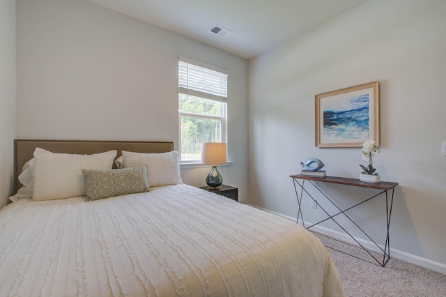 bedroom featuring light carpet, visible vents, and baseboards