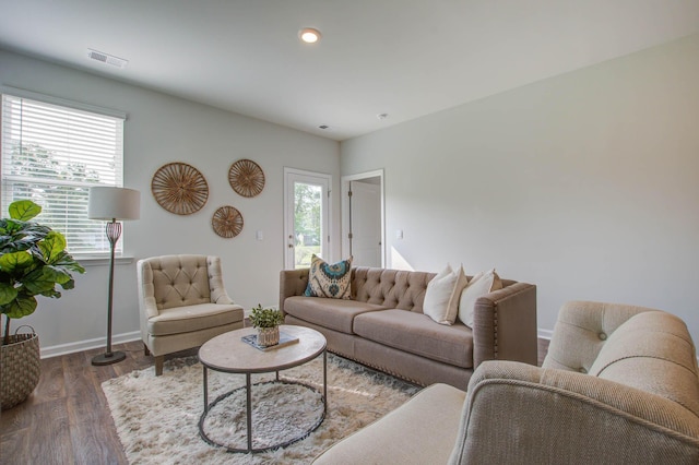 living room with plenty of natural light, wood finished floors, visible vents, and baseboards