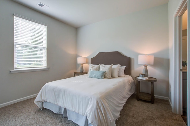 bedroom with baseboards, visible vents, and light colored carpet