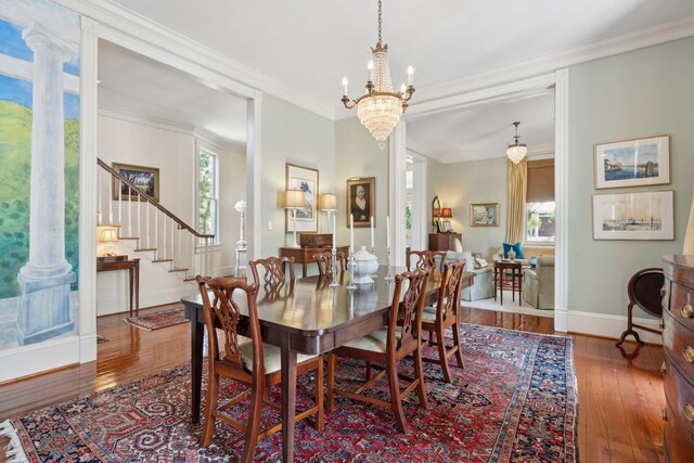 dining area with stairs, a wealth of natural light, and hardwood / wood-style flooring