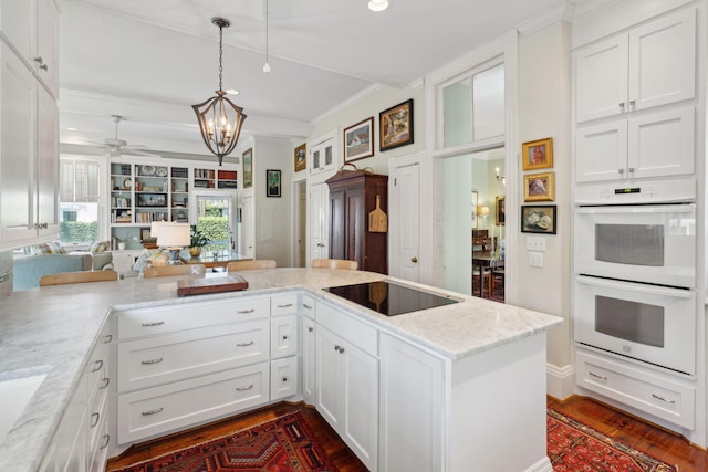 kitchen with white cabinets, dark wood-type flooring, white double oven, light stone counters, and black electric stovetop