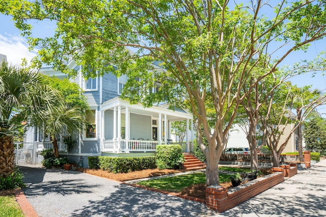 view of front of property featuring covered porch and gravel driveway