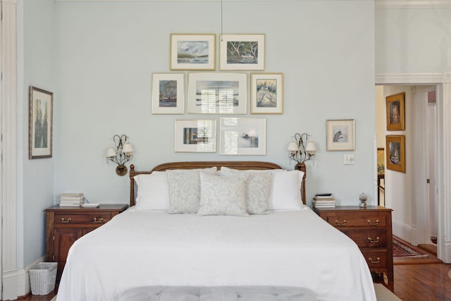 bedroom with baseboards and wood finished floors