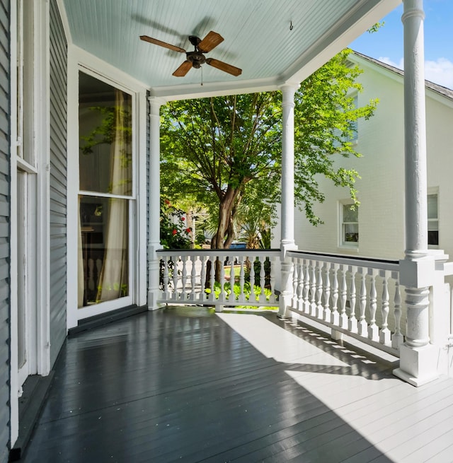 wooden terrace featuring covered porch and ceiling fan
