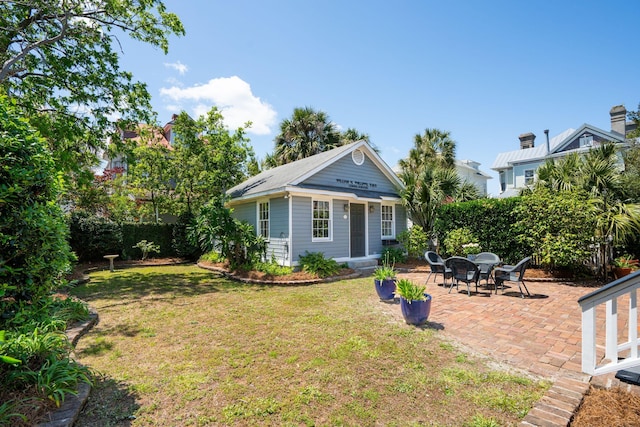 back of property featuring a patio area and a lawn