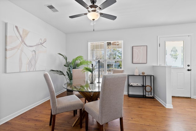 dining room with visible vents, a ceiling fan, light wood-type flooring, and baseboards