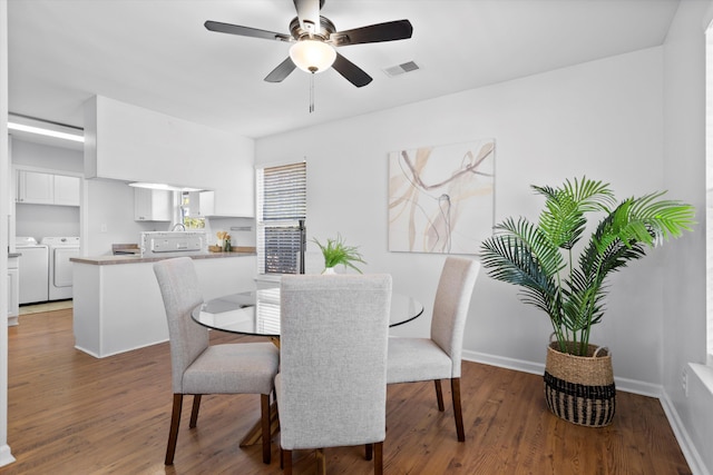 dining space with washer and dryer, wood finished floors, visible vents, and baseboards