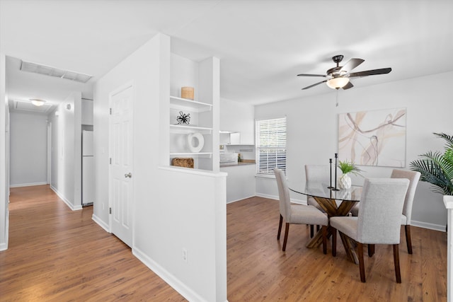 dining area featuring visible vents, baseboards, wood finished floors, and a ceiling fan