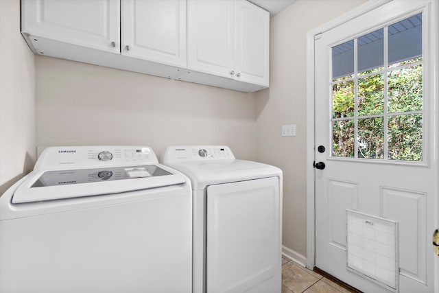 clothes washing area featuring light tile patterned floors, baseboards, cabinet space, and separate washer and dryer