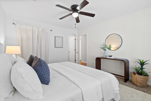 carpeted bedroom featuring baseboards and a ceiling fan