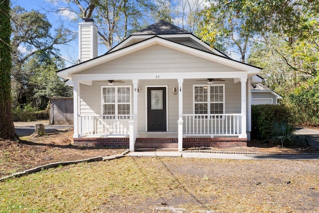 bungalow-style home with a porch, a chimney, and ceiling fan