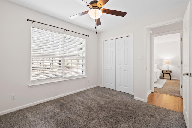 unfurnished bedroom with baseboards, a closet, carpet floors, and ceiling fan