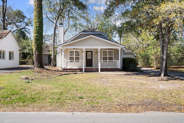 bungalow-style house with a porch and a chimney